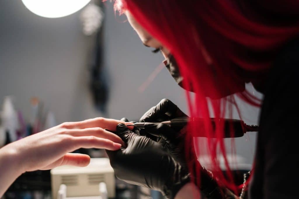 An image of nail technician treating nail